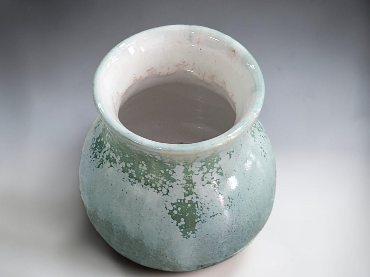 Mottled ceramic bud vase filled with waxflower and billy buttons