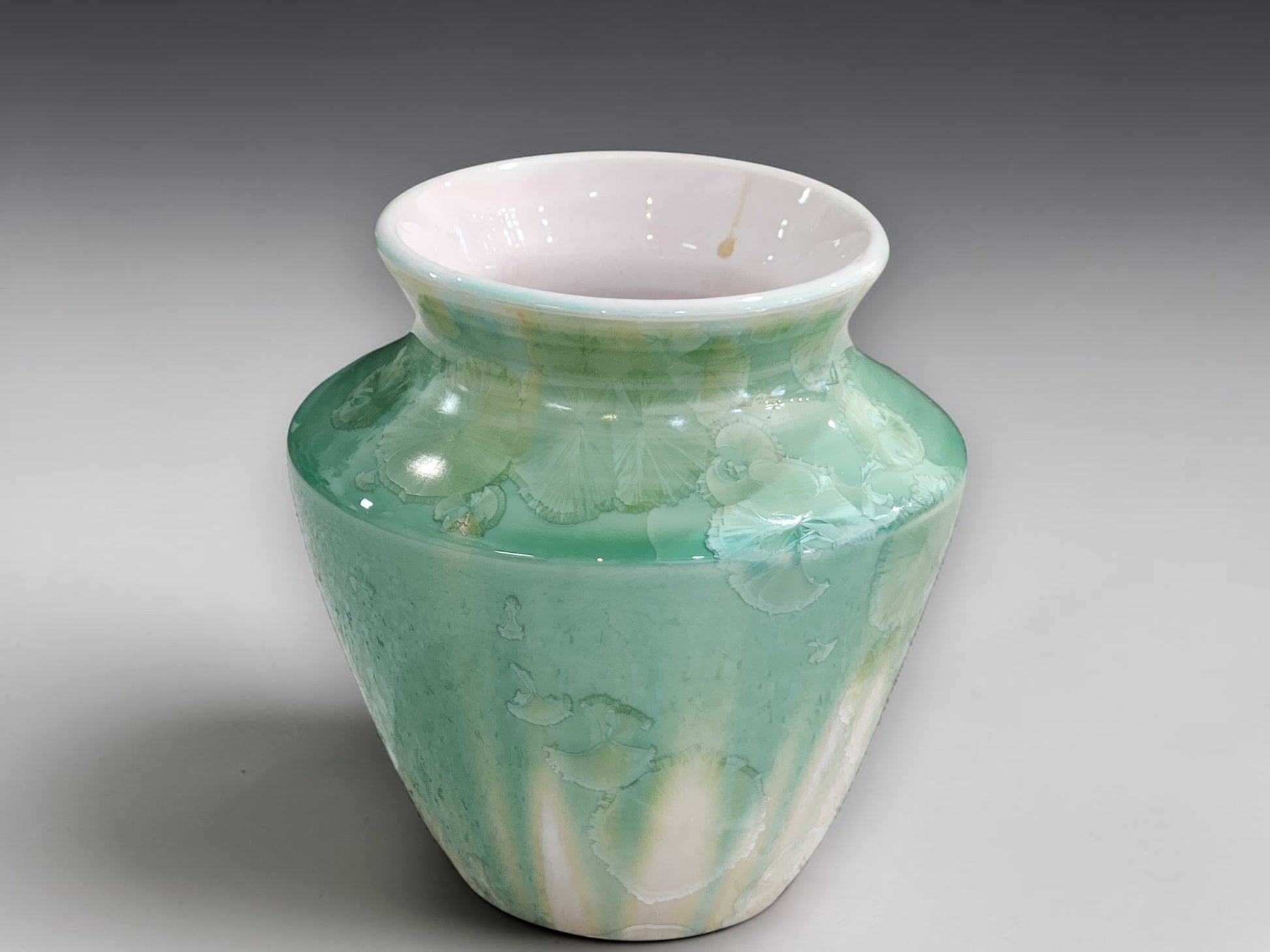 Front view of handmade soft green crystalline bud vase