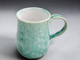 Front view of handmade green crystalline ceramic coffee mug