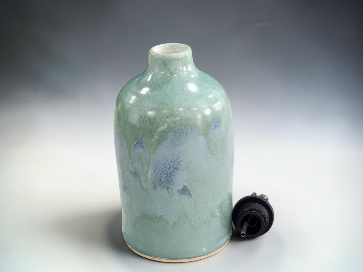 Handmade stoneware oil pourer with soft green mottled glaze