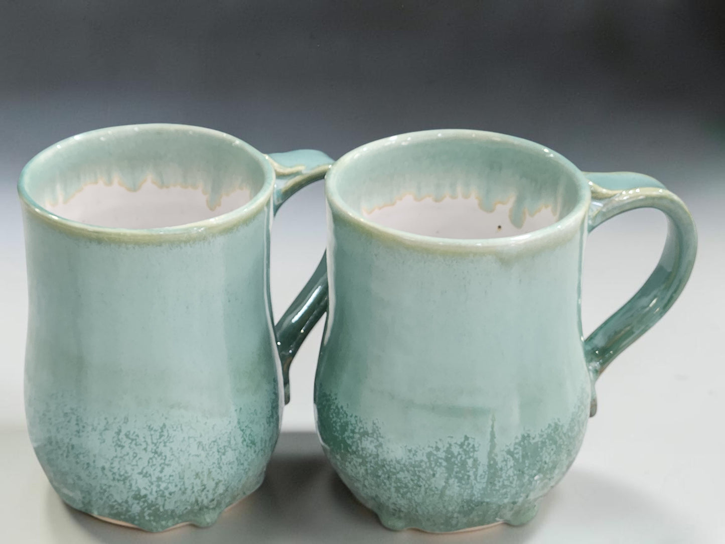 Handmade 450 ml and 500 ml pottery mugs in soft green glaze