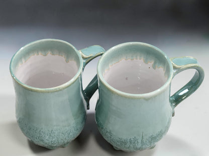 Tall ceramic mugs with rounded bellies and hand-pulled handles