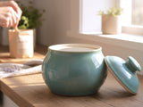 Handmade ceramic sugar bowl with lid in soft blue glaze on kitchen bench