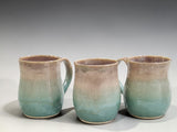 Handmade ceramic mugs with soft green and beige glaze, wheel-thrown stoneware pottery