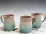 three handmade pottery mugs with soft green and neutral glaze, wheel-thrown stoneware mugs