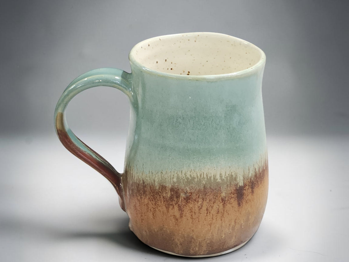 Handmade mug with layered green, cream and brown glaze