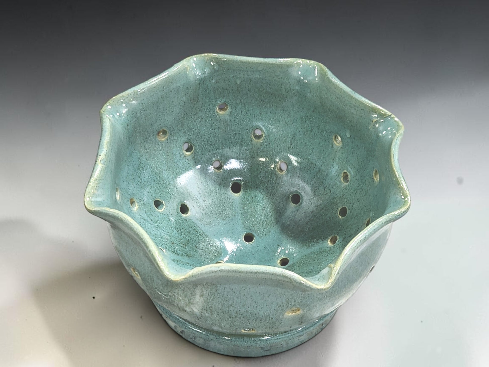 Handmade stoneware berry bowl with saucer in glossy pale green glaze