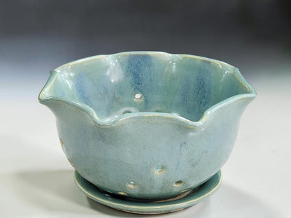 Green pottery fruit bowl with decorative wavy rim