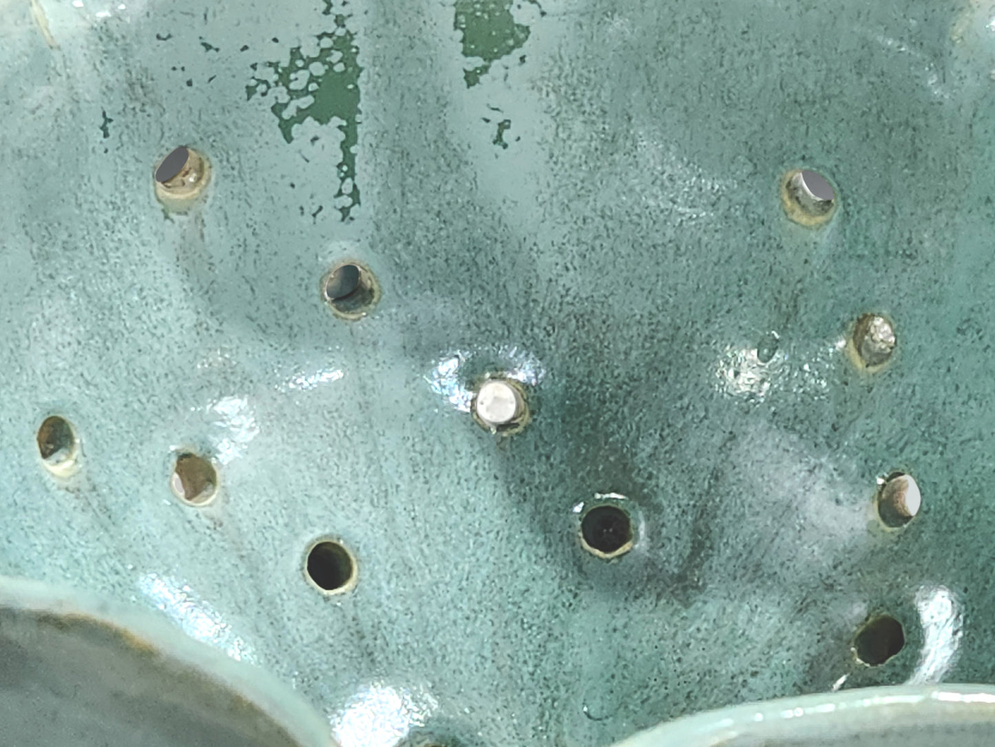 Close-up of spearmint green glaze on handmade ceramic berry bowl with matching saucer