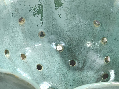 Close-up of spearmint green glaze on handmade ceramic berry bowl with matching saucer