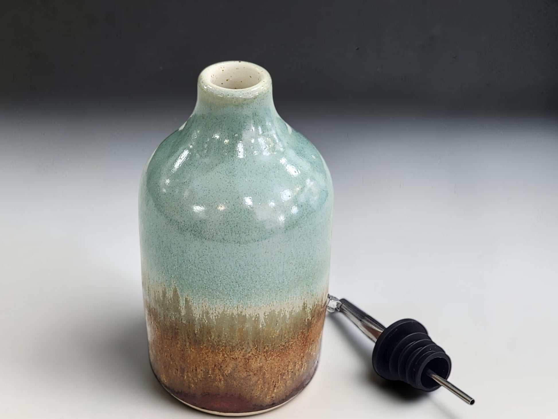 Wheel-thrown spearmint green oil bottle with stainless-steel pourer