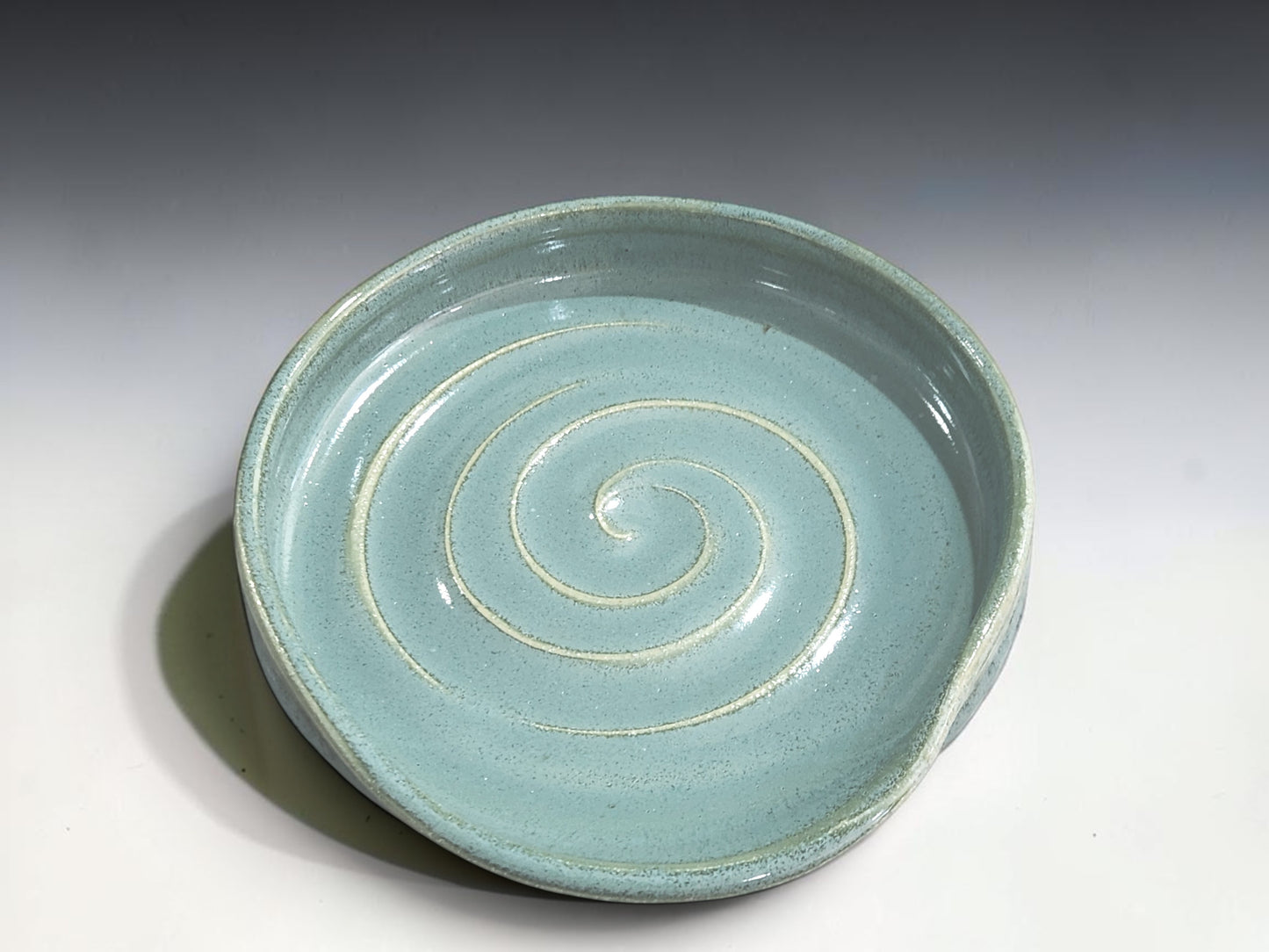 Australian handmade stoneware spoon rest in a soft spearmint green glaze, perfect for everyday kitchen use.