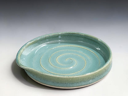 Close-up of handmade spearmint green ceramic spoon rest showing glossy food-safe stoneware glaze and spiral pattern.