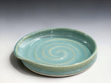 Close-up of handmade spearmint green ceramic spoon rest showing glossy food-safe stoneware glaze and spiral pattern.