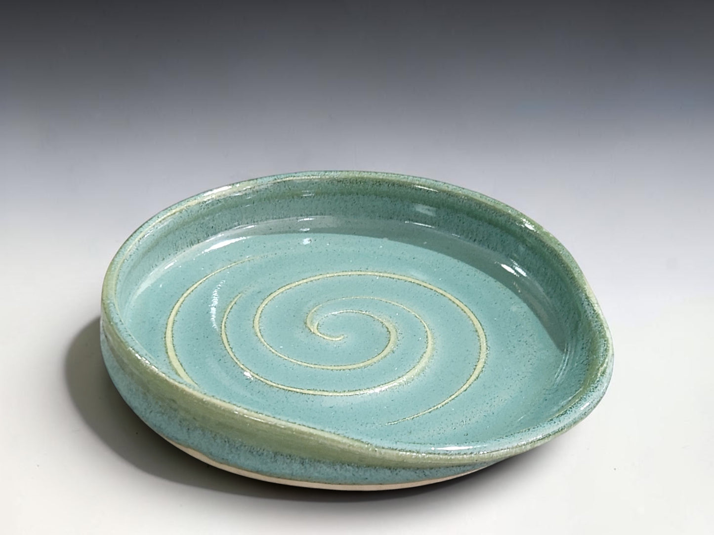 Small handmade pottery spoon rest in calming spearmint green for wooden spoons, ladles and cooking utensils.