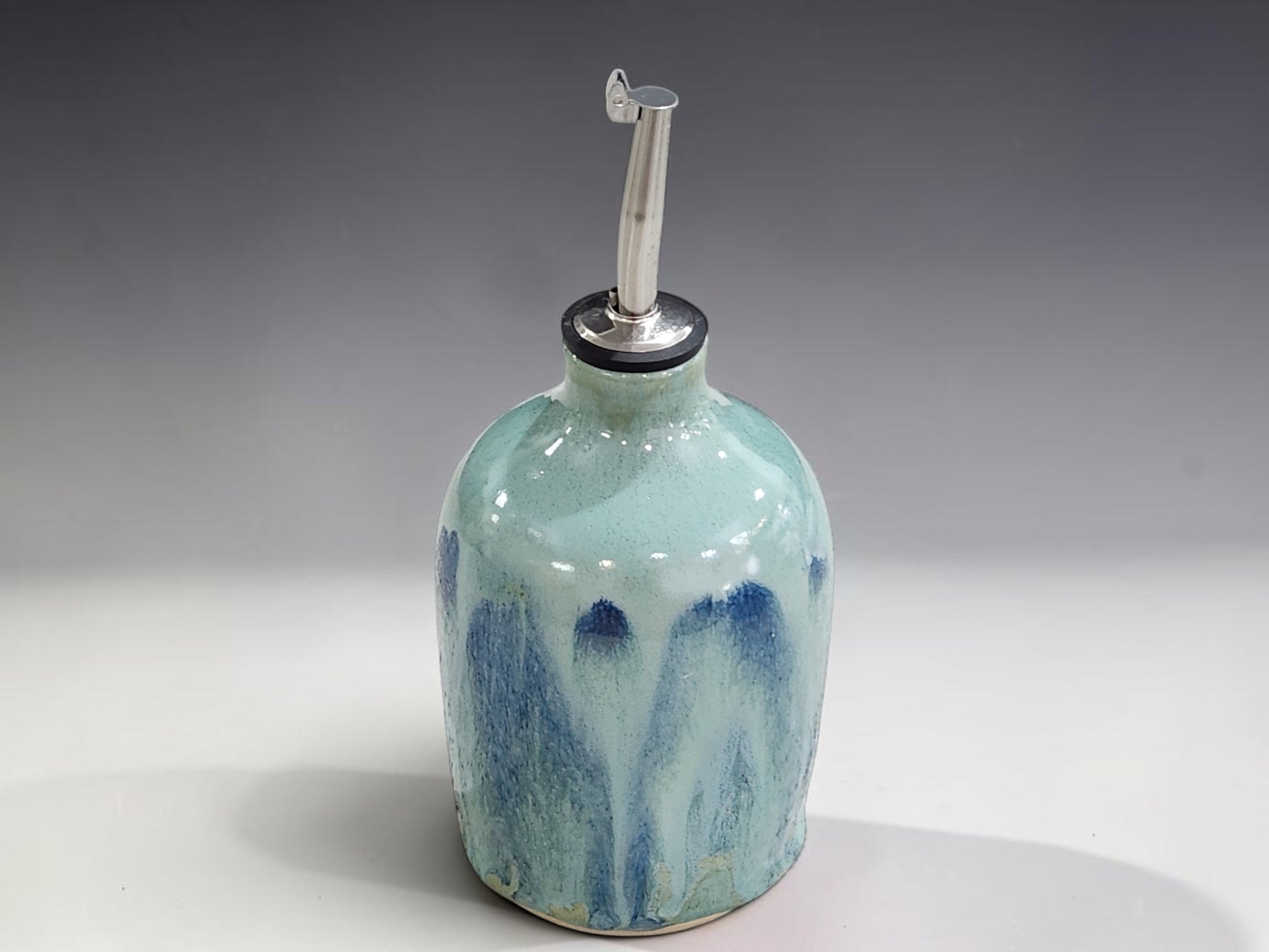 Ceramic olive oil bottle in soft aqua blue glaze with unique handmade pottery finish
