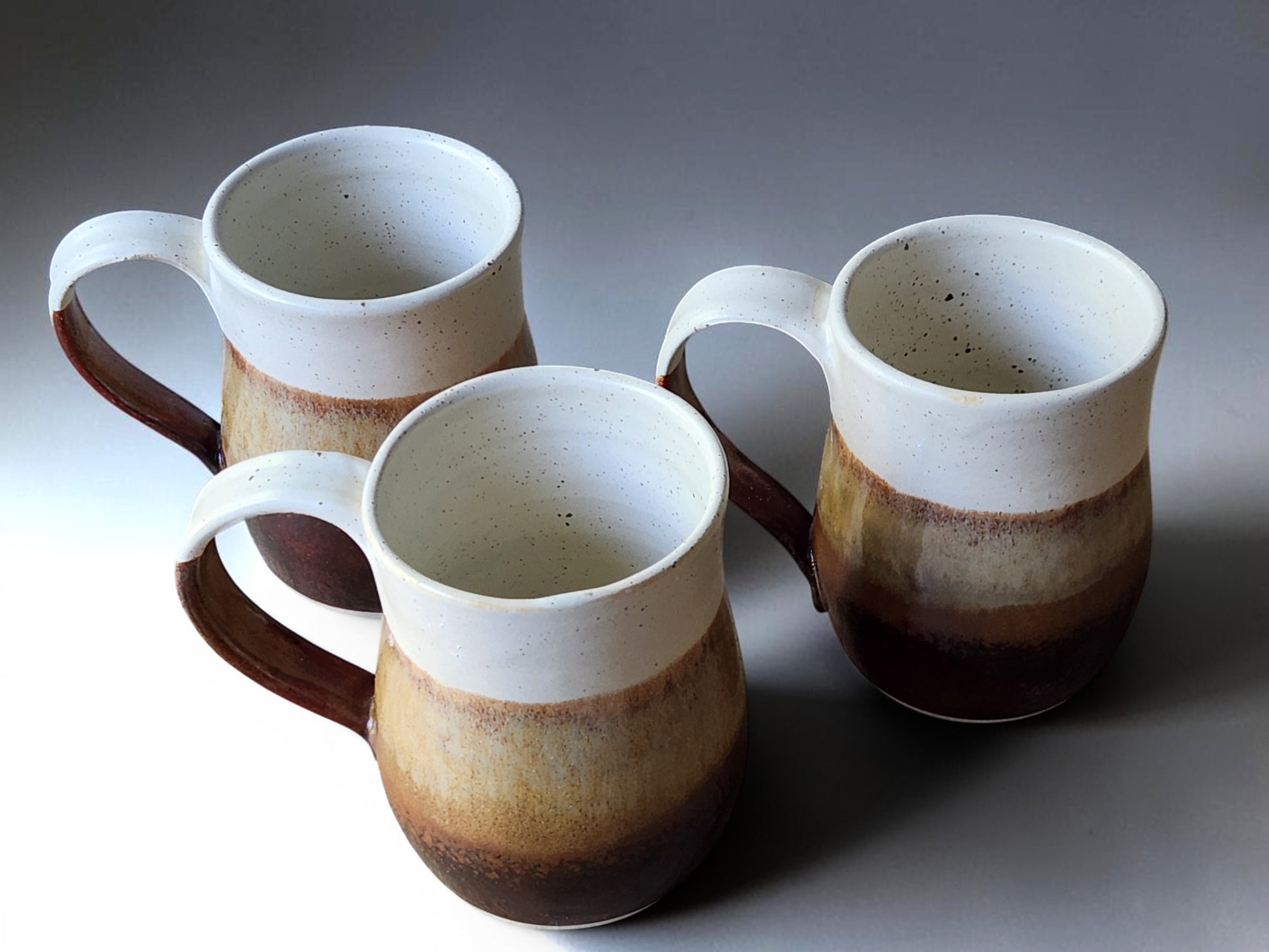 Rustic stoneware mugs with cream upper glaze and deep brown base