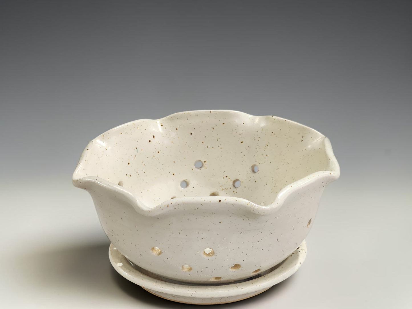 Handmade pottery berry bowl with drainage holes and saucer for rinsing and serving fresh strawberries