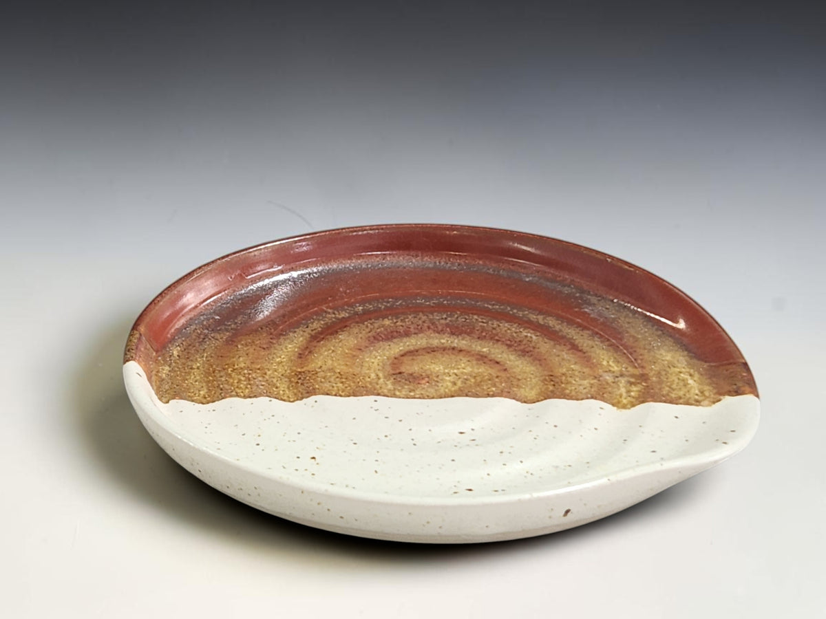 Rustic pottery spoon rest with speckled cream and warm brown glaze