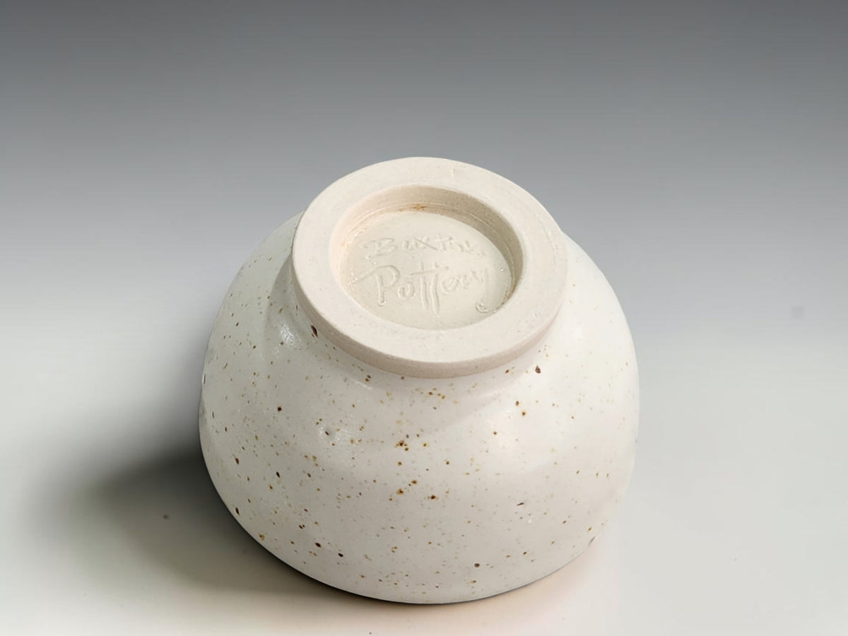 Speckled cream pottery bowl with a rounded rim and an unglazed base