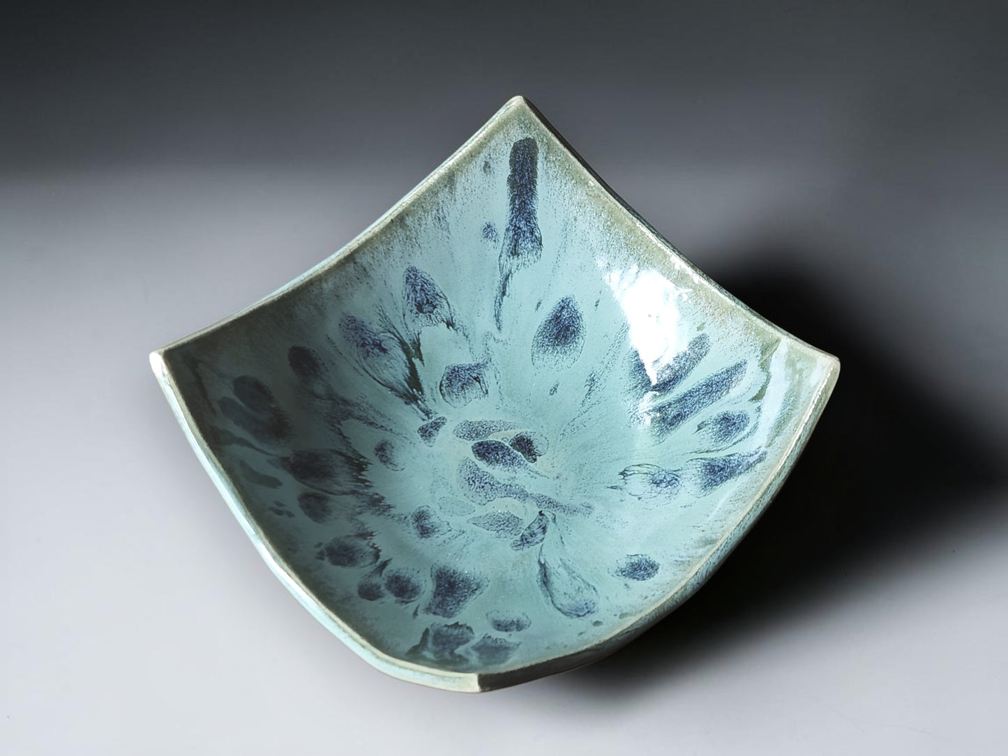 Handcrafted ceramic centerpiece bowl with soft green and blue glaze.