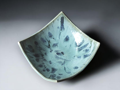 Handcrafted ceramic centerpiece bowl with soft green and blue glaze.