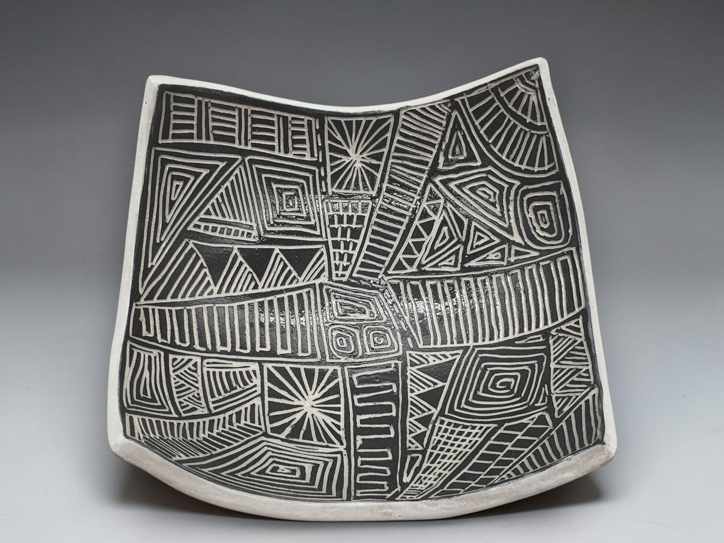 Handcrafted black and white carved drape bowl with geometric tribal-inspired patterns