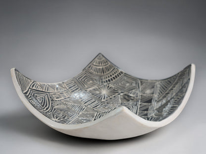 Artisan pottery bowl featuring hand-carved black and white abstract linework