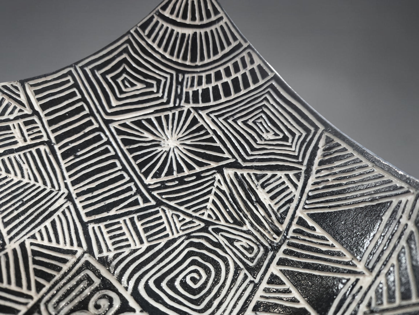 Close up of a Decorative sculptural bowl with curved drape edges and intricate geometric design