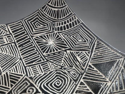 Close up of a Decorative sculptural bowl with curved drape edges and intricate geometric design