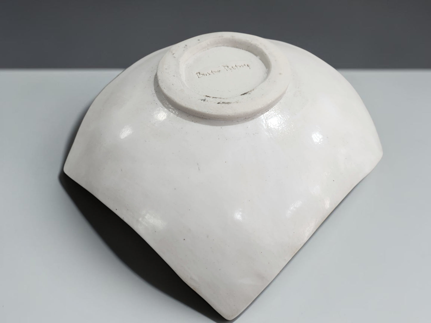 Under side of a Unique drape-style ceramic bowl with tribal-inspired etched pattern and organic shape