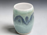 Wheel-thrown pottery vase with landscape-inspired green and blue glaze.