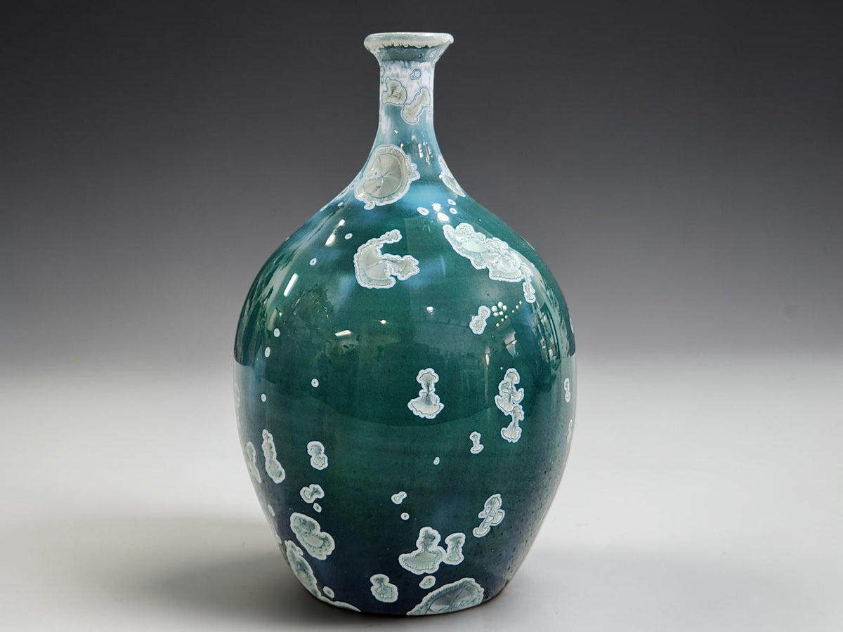 Front view of the handmade crystalline vase with a rounded belly, slender neck and flared rim.