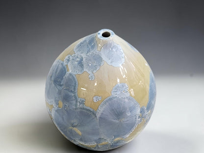 Angled view of the blue and cream ceramic pot showing overlapping circular crystal patterns.