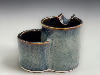SIde view of Handmade ashtray  with glossy dark rim and soft blue glaze