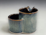 SIde view of Handmade ashtray  with glossy dark rim and soft blue glaze