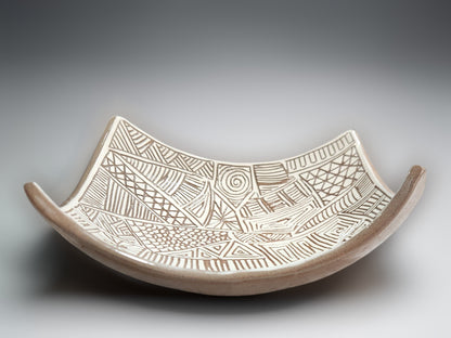 Sculptural ceramic bowl with elevated corners and intricate white slip carved detailing