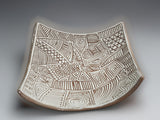 Artisan pottery bowl with carved white slip interior and sculptural curved silhouette