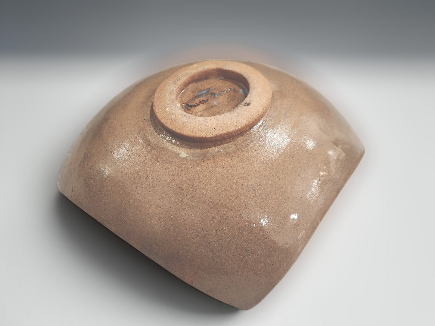 underside of a Handmade ceramic serving bowl with carved geometric motifs and earthy natural glaze