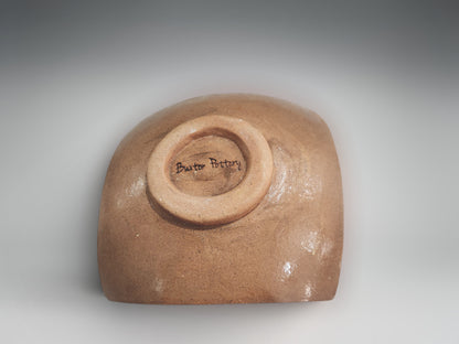 Under side of a Sculptural ceramic bowl-plate in earthy terracotta finish with intricate carved detailing