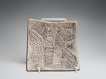 Small carved terracotta bowl-plate styled on a display stand