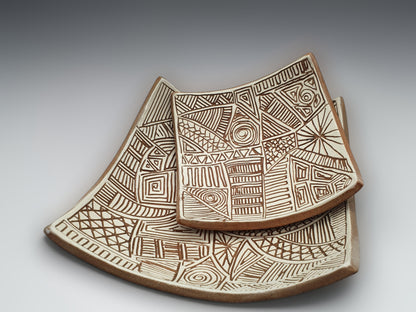 Two Handcrafted decorative terracotta dishes with carved abstract linework and natural clay tones