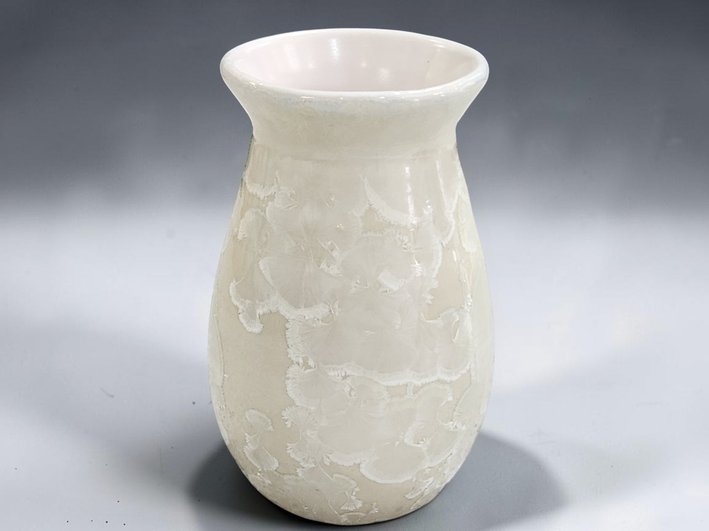 White pottery vase with rounded body and wide flared opening