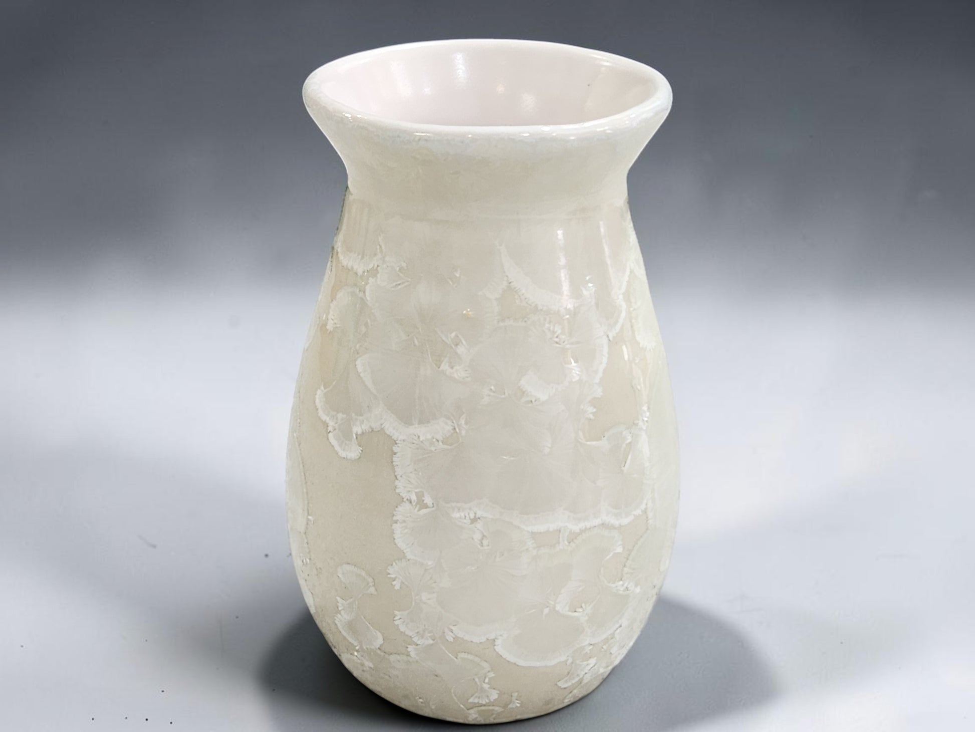 White pottery vase with rounded body and wide flared opening