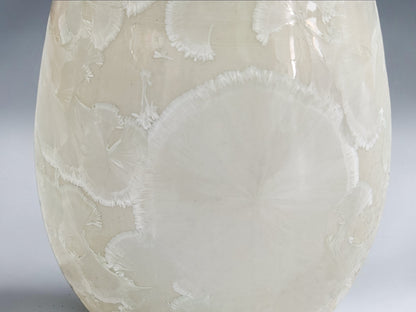 Close-up of naturally formed crystal patterns on a white porcelain vase